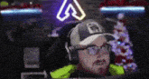 a man wearing a hat and headphones is sitting in front of a computer .