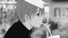 a black and white image of a boy drinking through a straw