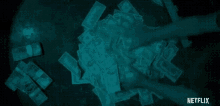 a person is holding a pile of money in their hands in a dark room .