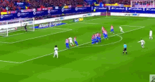a group of soccer players on a field with a banner that says allianz seguros on it