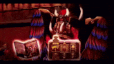 a cartoon of a demon reading a book with the words congratulations written below it