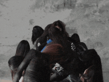 a group of women are huddled together with one wearing a shirt that says ' i am here ' on it
