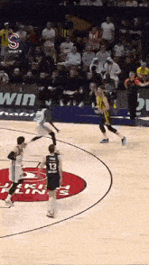 a basketball game is being played on a court that has a sign that says win on it