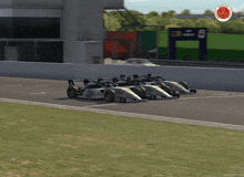 a row of race cars are lined up on a track with a nhk logo in the background