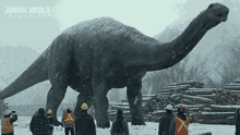 a group of people standing in front of a large dinosaur that says jurassic world on the bottom