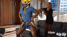 a gif of a woman standing next to a man with a mask on his face