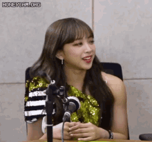 a woman is sitting in front of a microphone .