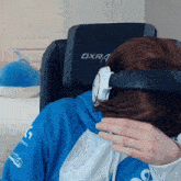 a person wearing headphones is sitting in a chair that says dxra
