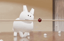 a white object is hanging from a string next to a red object .