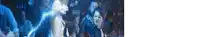 a blurry picture of a group of people standing in a dark room with a blue light coming out of the ceiling .