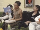 a group of people are sitting on a couch reading a book titled you deserve better