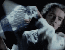 a man in a white shirt with the letter r on it