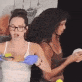 a woman wearing glasses and blue gloves holds a plate of food