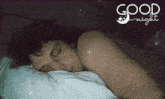a man is sleeping in a bed with the words " good night " written above him
