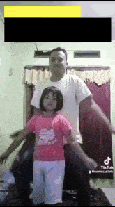 a man and a little girl are dancing in a room