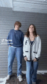 a man and a woman are dancing in front of a building with tiktok written on the bottom