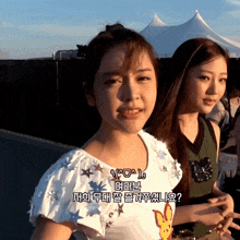 two girls are standing next to each other and one of them is wearing a shirt with stars on it