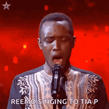 a man singing into a microphone with the words reemo singing to tia p written on the bottom