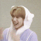 a young man wearing a bunny hat is covering his face with his hands .