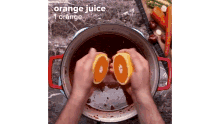 a person is cutting an orange into a pot of orange juice