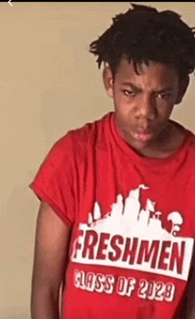 a young man wearing a red freshmen class of 2029 shirt