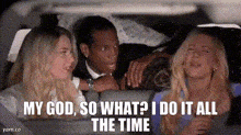 a man and two women are sitting in the back seat of a car . the man is driving .