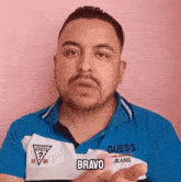 a man wearing a blue and white guess polo shirt says bravo