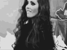 a woman with long hair is smiling in a black and white photo