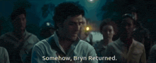 a man stands in front of a group of people and says somehow bryn returned