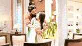 a man with a beard is hugging a woman in a living room .