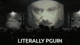 a crowd of people watching a man on a screen with the words literally pguin on the bottom