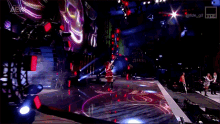 a woman is dancing on a stage in front of a large screen that says ' ae ' on it