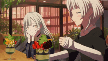 two anime girls are sitting at a table with a bowl of food in front of them