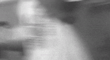 a blurry black and white photo of a person 's back .
