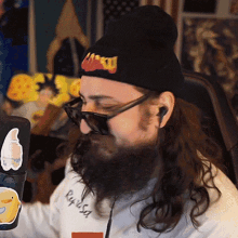 a man with a beard is wearing sunglasses and a beanie with the word mtv on the front