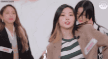 a group of young women are standing next to each other in front of a wall .
