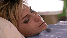 a woman is laying in a hospital bed with her eyes closed and her mouth open
