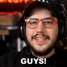 a man with a beard wearing headphones and red glasses says guys