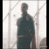 a man in a superhero costume is looking out a window