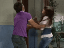 a man in a purple shirt and a woman in a white shirt are dancing together