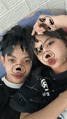 a boy and a girl are posing for a picture with their faces painted with drawings