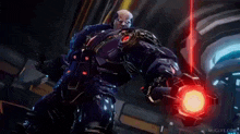 a man in a futuristic suit is holding a red object in a video game .
