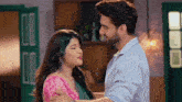 a man and a woman are hugging and kissing in a room .
