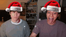 two men wearing santa hats with their tongues hanging out