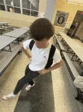 a boy wearing a white shirt with an air jordan logo on the front