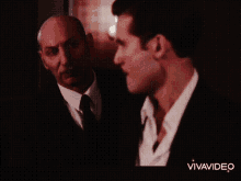 a man in a suit is talking to another man in a white shirt in a vivavideo video