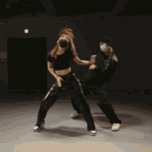 a man and a woman wearing masks are dancing