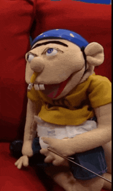 a puppet with a diaper on is sitting on a couch