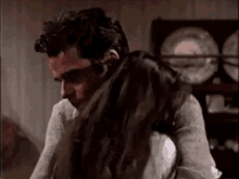 a man and woman are hugging each other in a room .