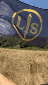 a person is holding a flag that says lts in a field